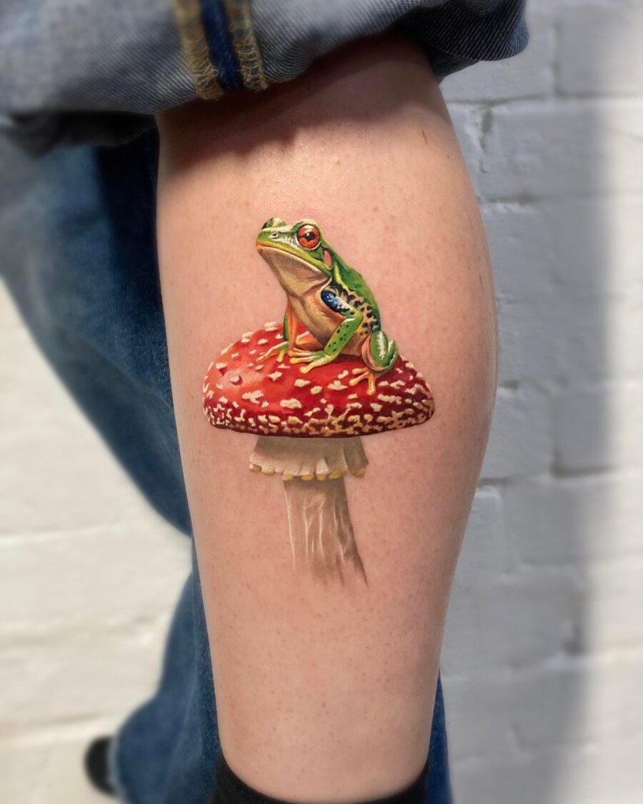 Stunningly realistic frog on a mushroom tattoo
