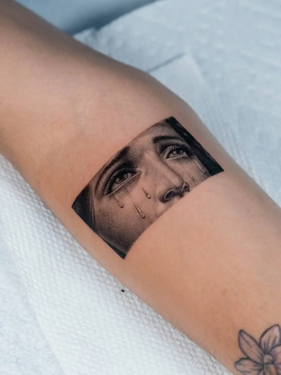Expressive face tattoo with realistic tears
