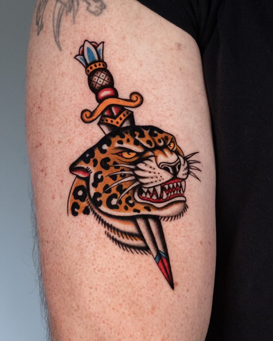 Elegant leopard tattoo with dagger detail