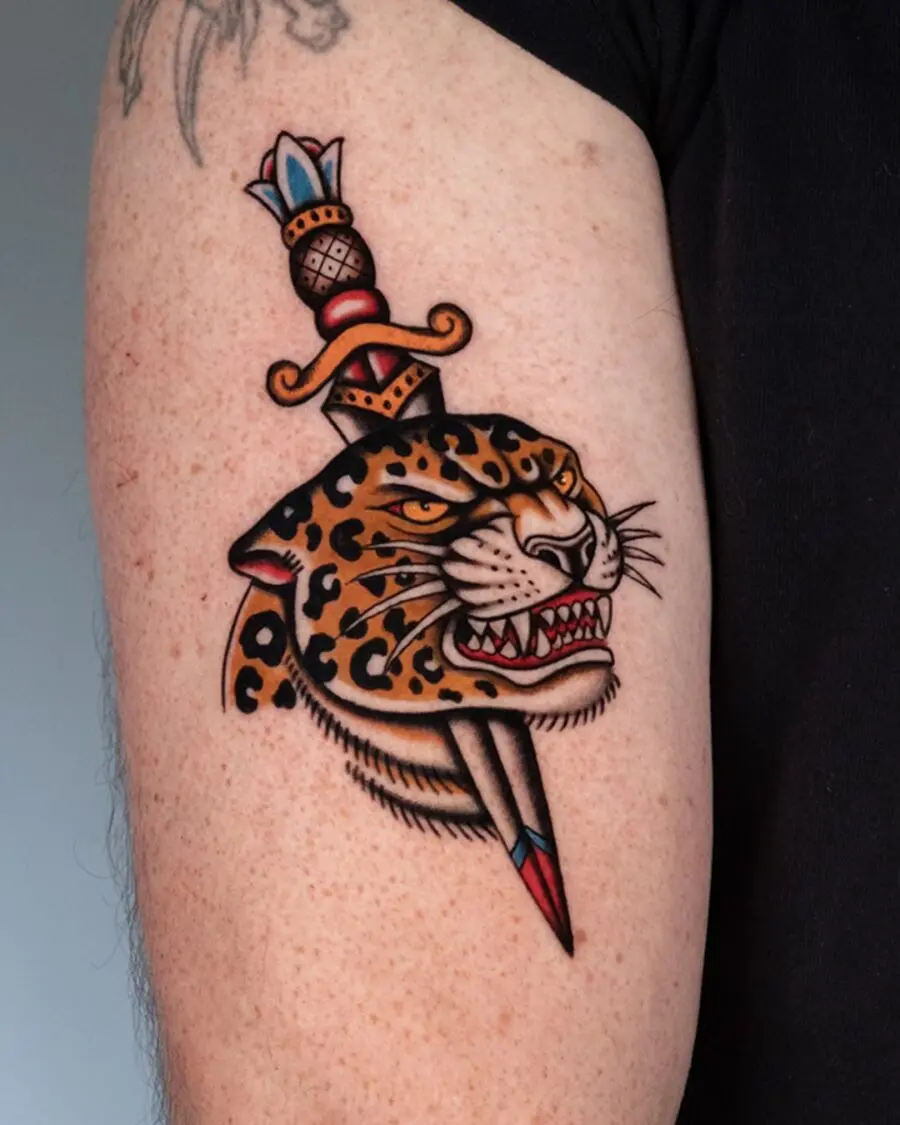 Elegant leopard tattoo with dagger detail