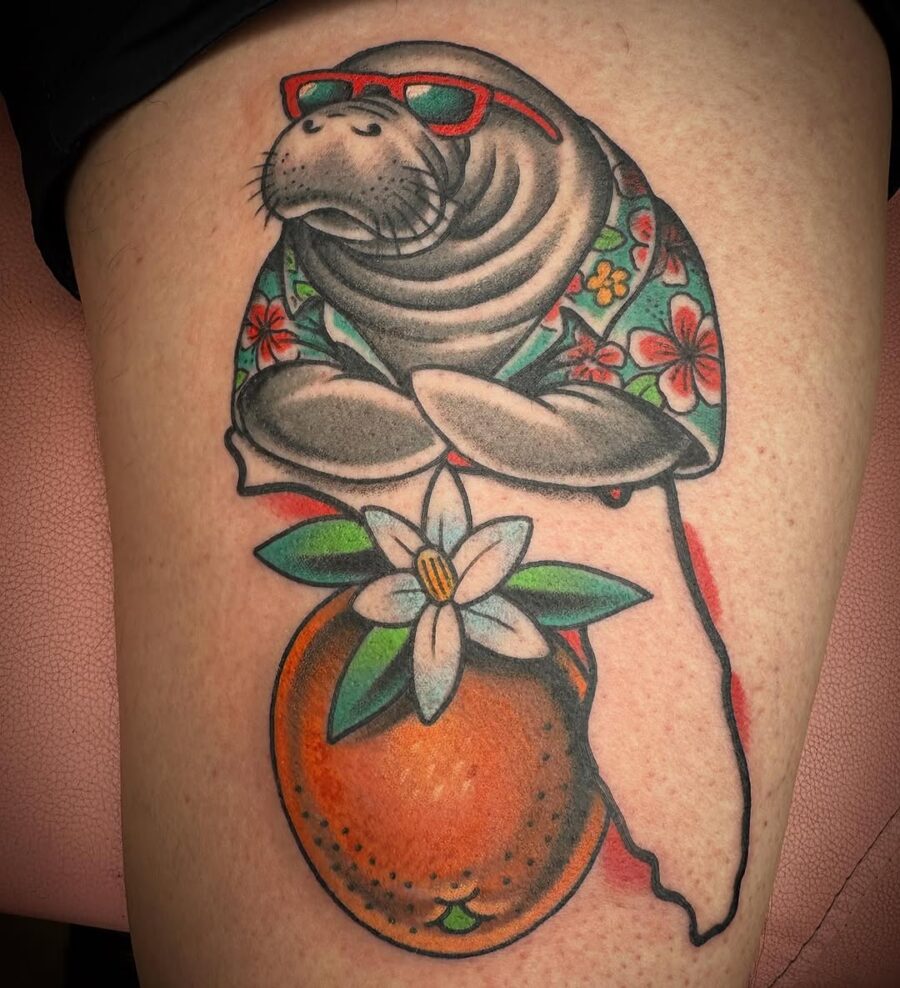 Colorful manatee tattoo with floral elements