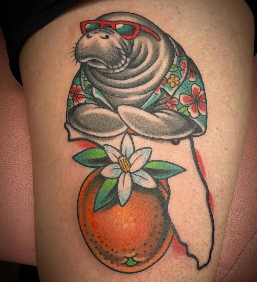 Colorful manatee tattoo with floral elements