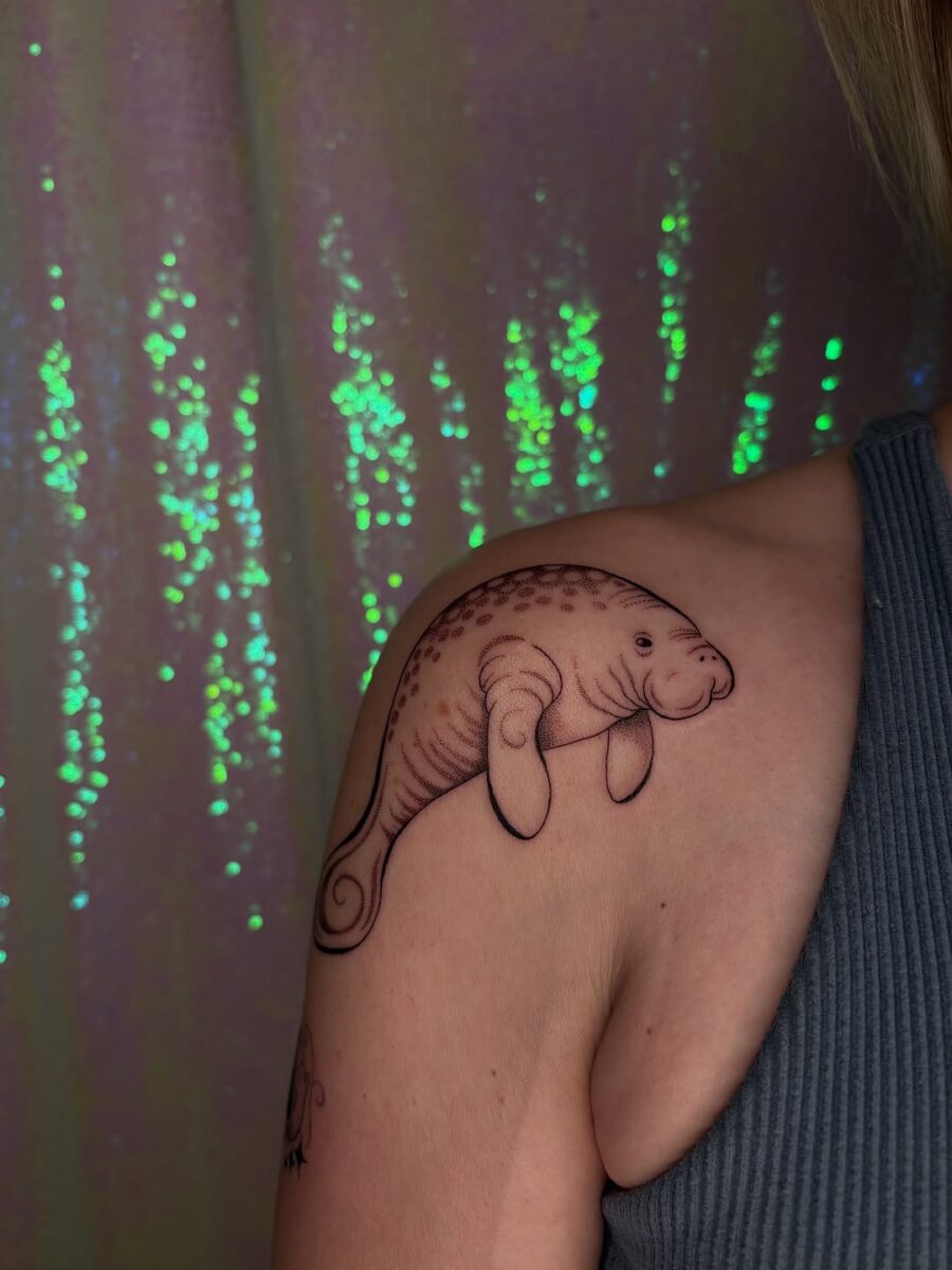 Charming manatee tattoo on shoulder