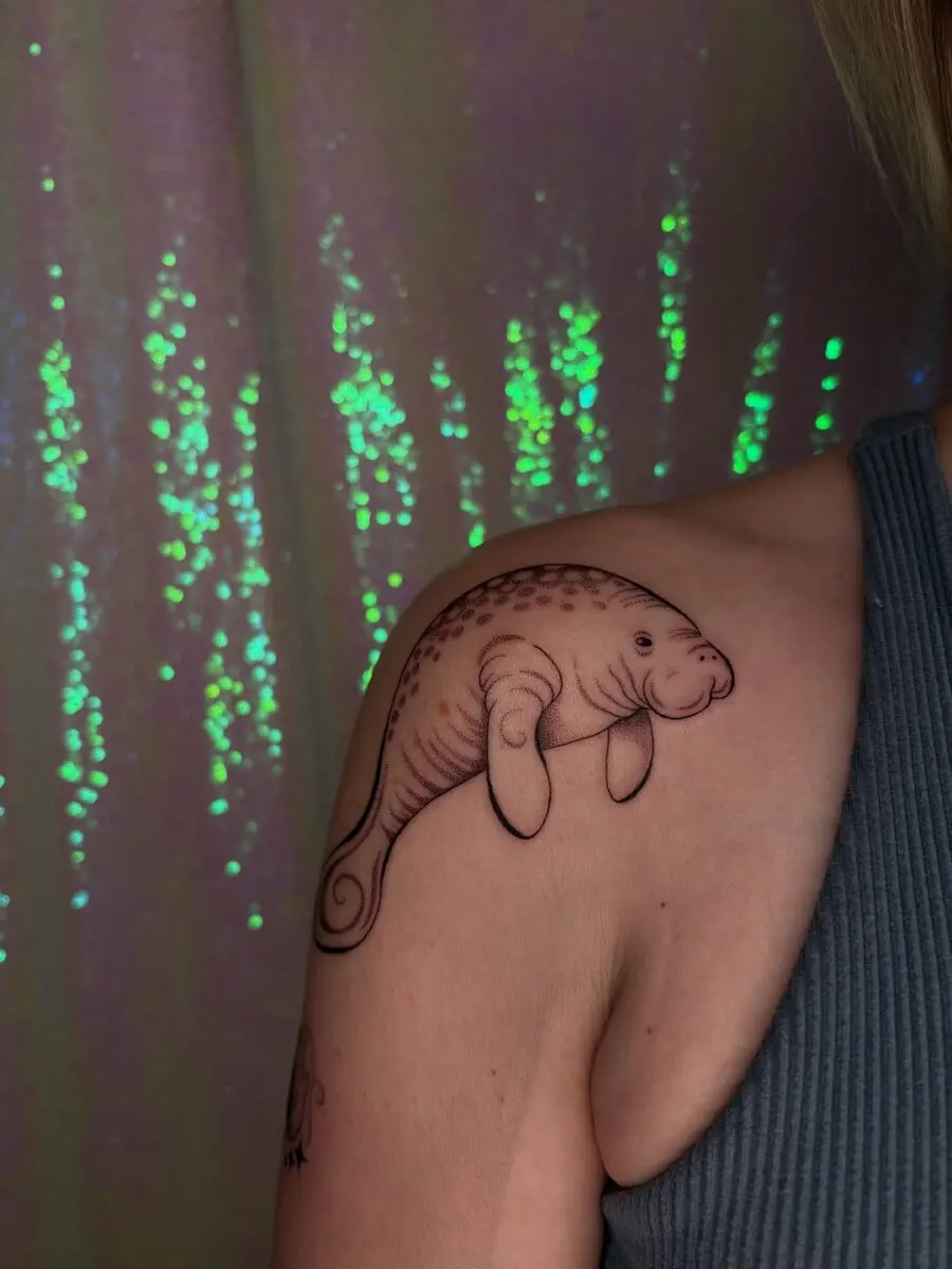Charming manatee tattoo on shoulder