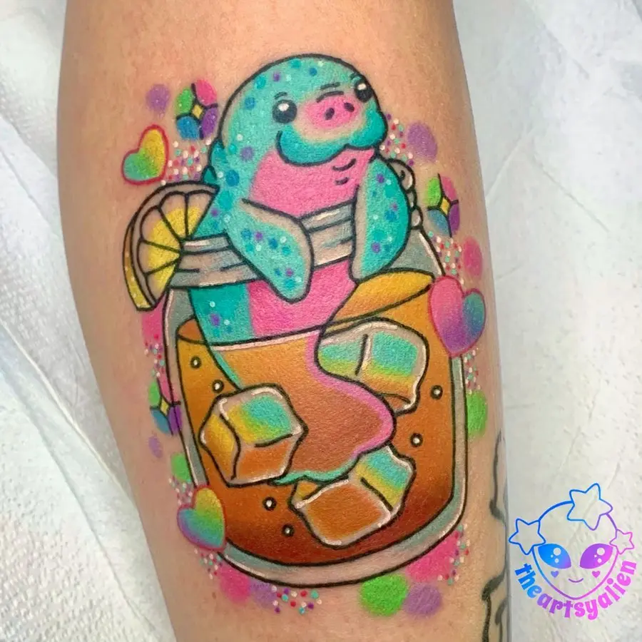 Playful manatee enjoying a tropical drink tattoo