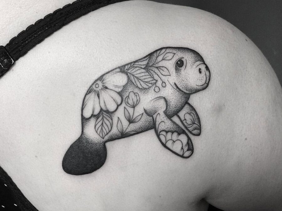 Charming manatee tattoo adorned with floral elements