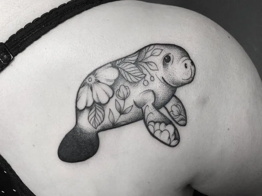 Charming manatee tattoo adorned with floral elements