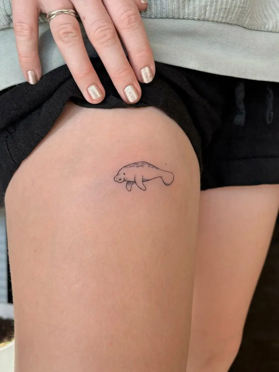 Cute minimalistic manatee tattoo on thigh