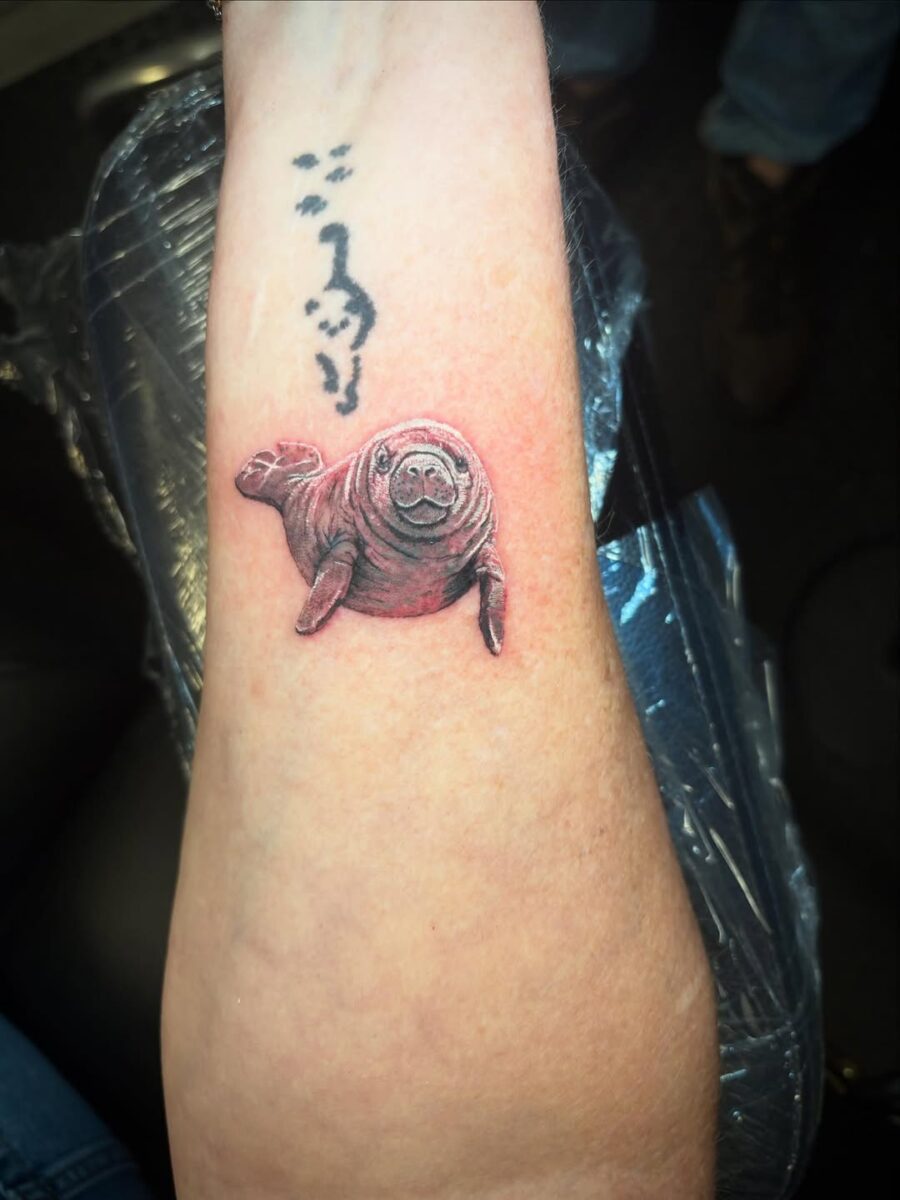 Vibrant Manatee Tattoo on Arm's Skin