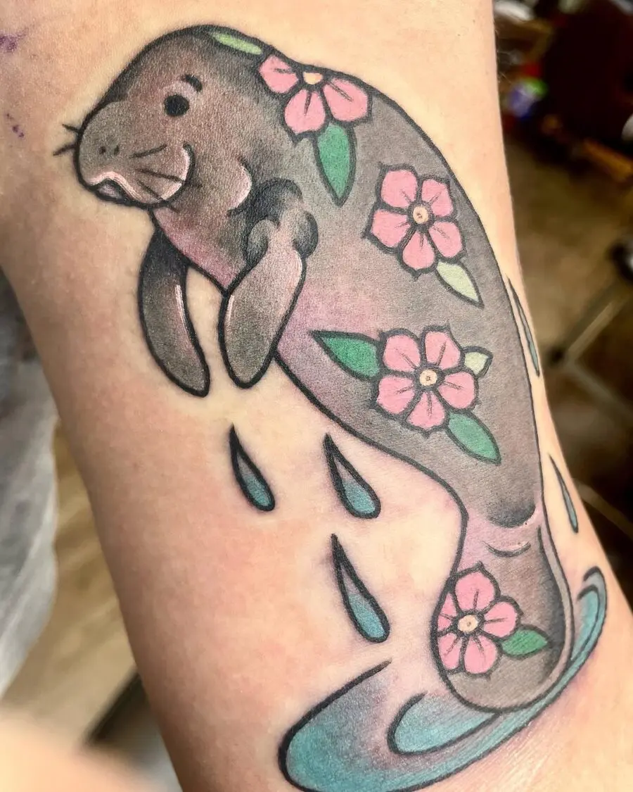 Charming manatee tattoo with floral accents