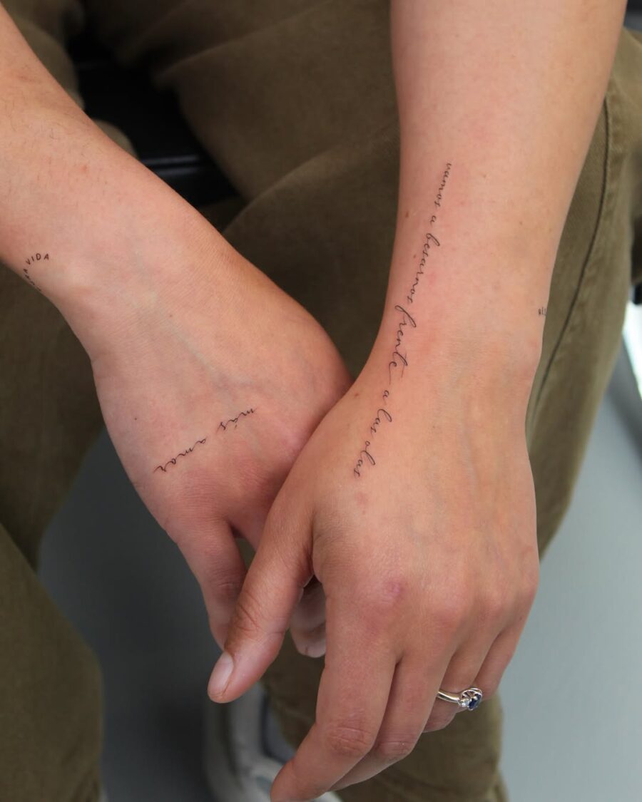 Elegant handwriting tattoos on well-defined arms.