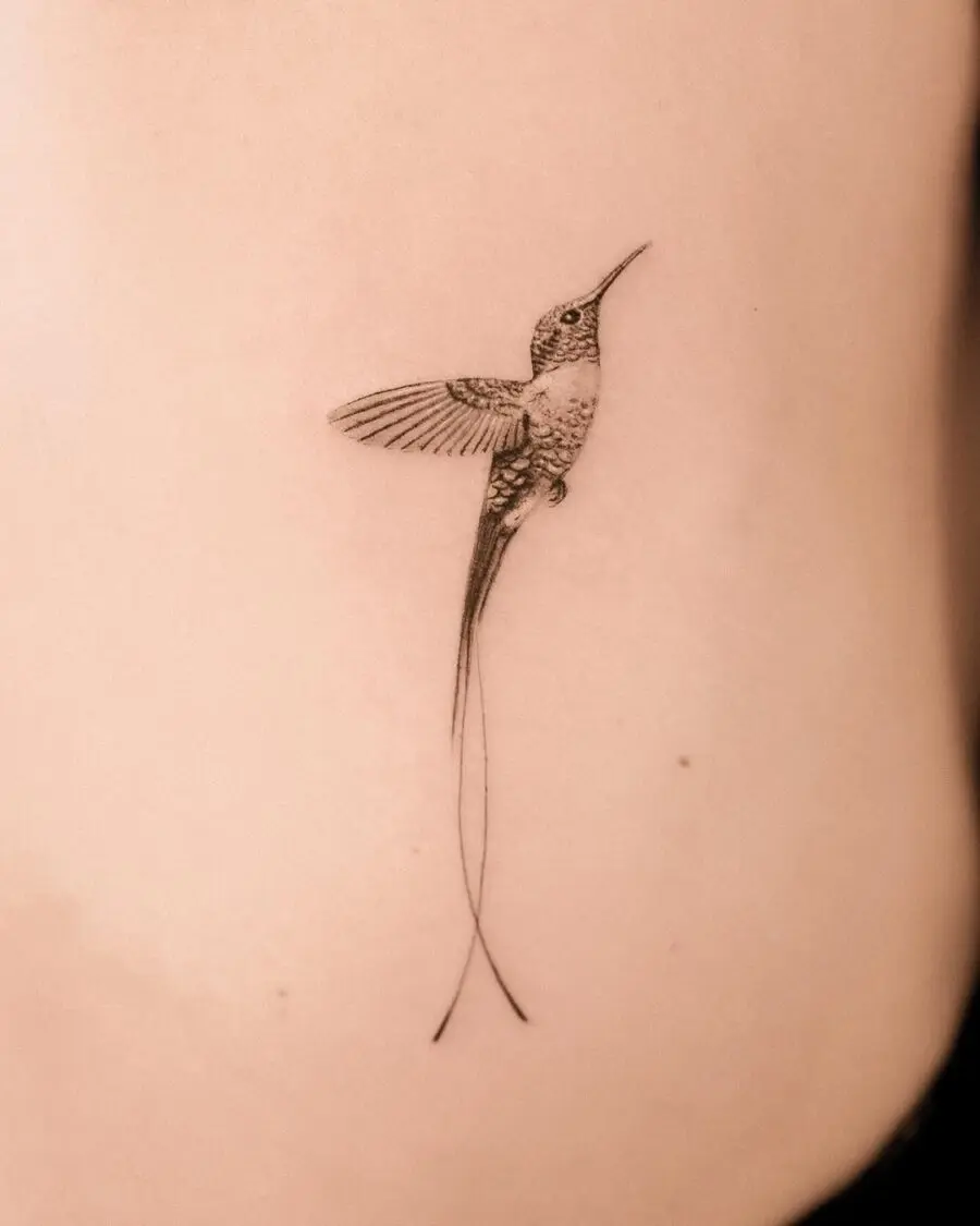 Elegant hummingbird tattoo with delicate lines.