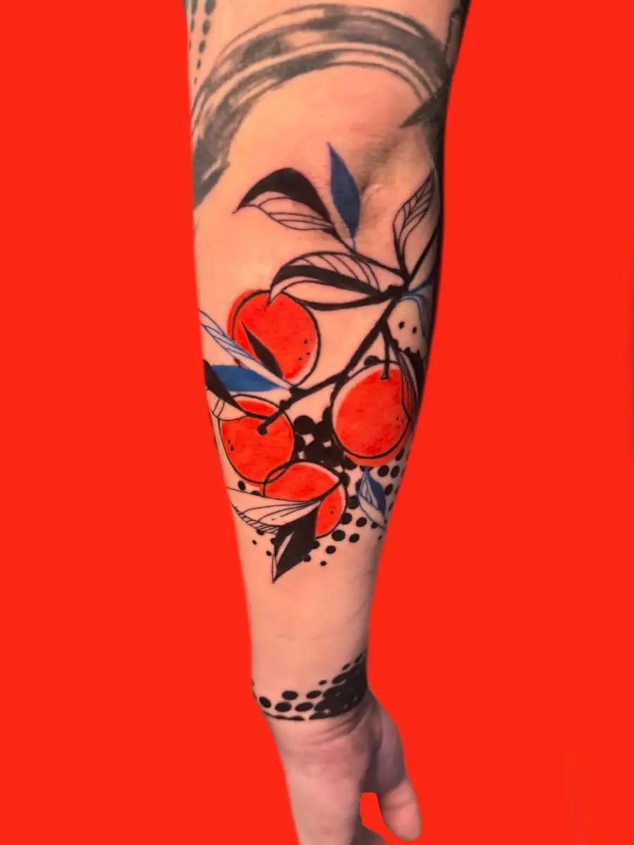 Vibrant orange fruit tattoo with bold foliage