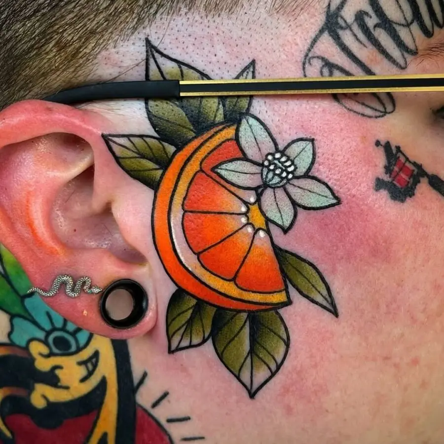 Vibrant orange tattoo with floral accents on skin.