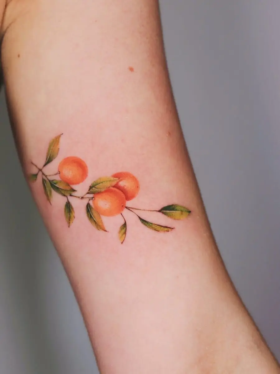 Vibrant orange tattoo with delicate leaves