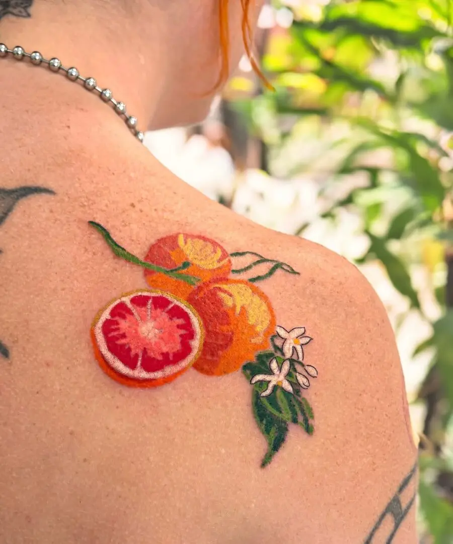 Vibrant orange tattoo with delicate floral accents