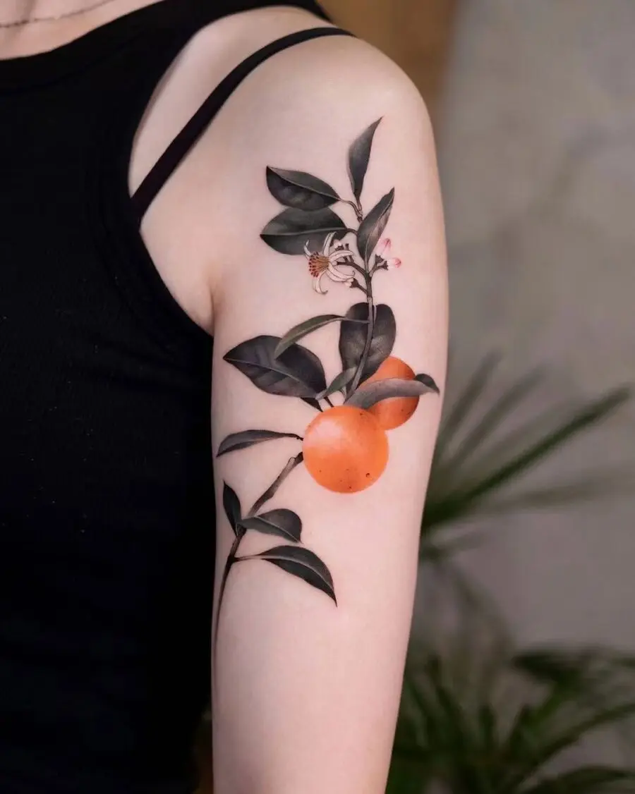 A vibrant orange tattoo surrounded by leaves