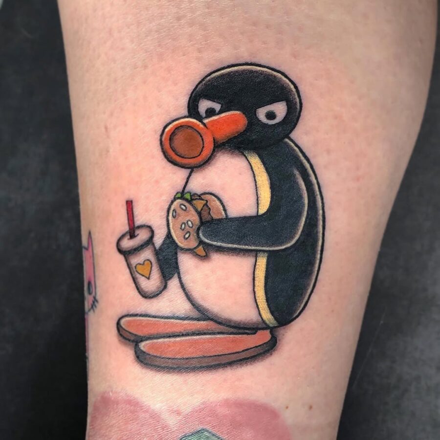 Quirky penguin enjoys a tasty burger tattoo