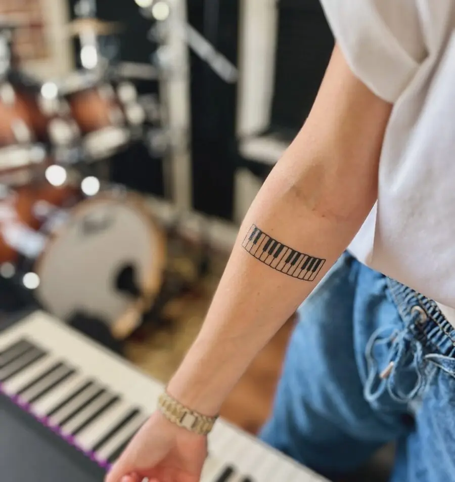 Elegant piano keys tattoo on forearm