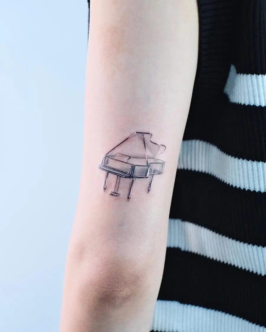 Elegant minimalist piano tattoo on forearm