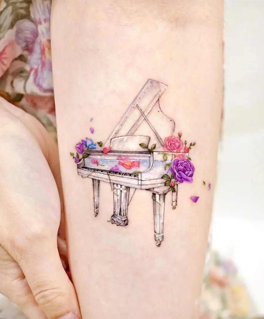 Whimsical piano tattoo adorned with flowers