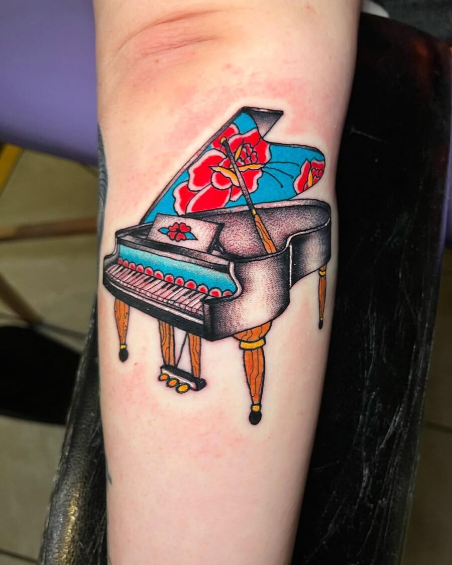 Vibrant grand piano tattoo with floral elements