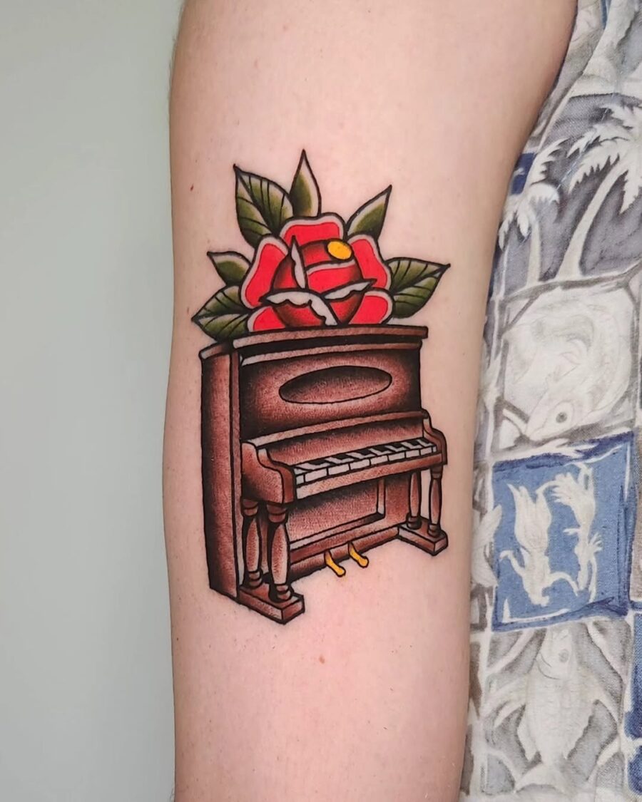 Elegant piano tattoo with vibrant floral accents