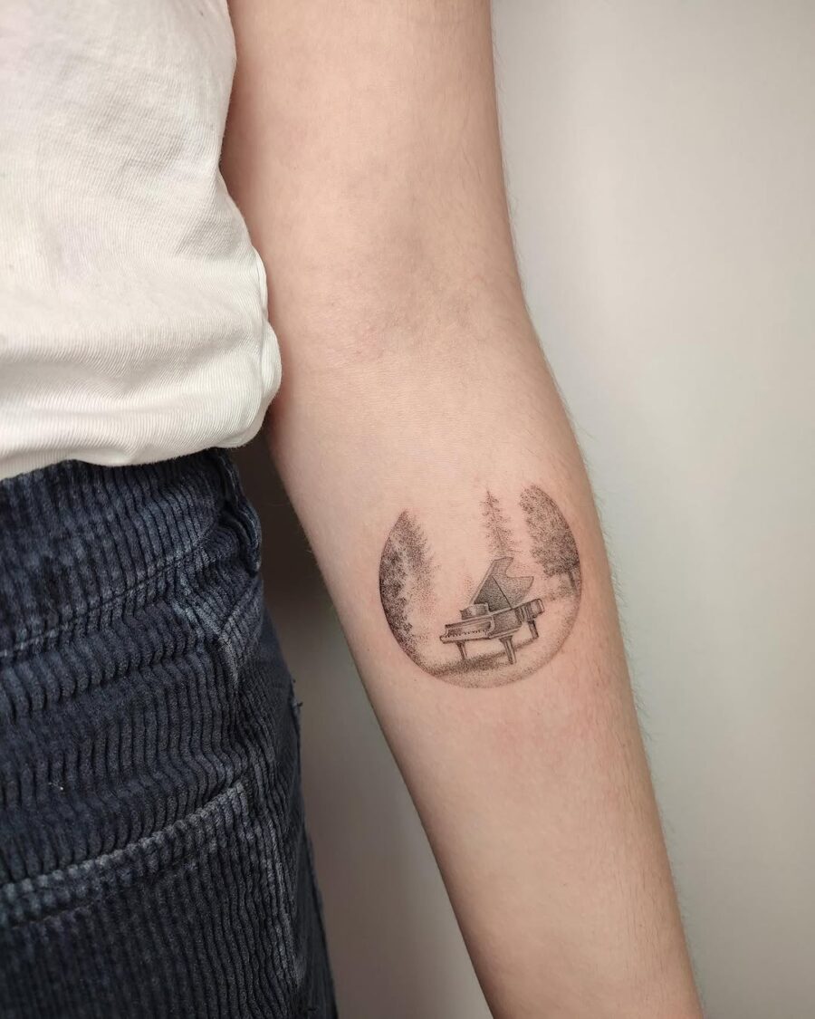 Beautiful piano tattoo within a forest circle