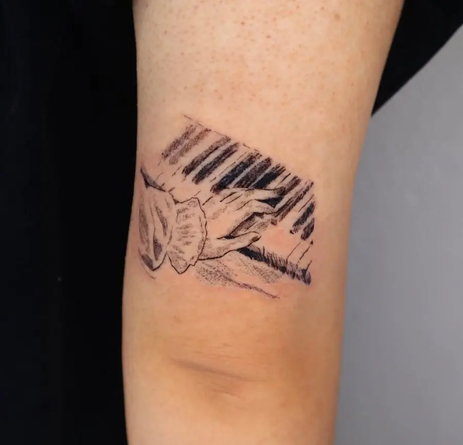 Intricate piano tattoo showcasing hands in harmony