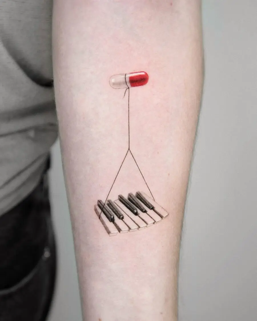 Creative piano and pill tattoo design