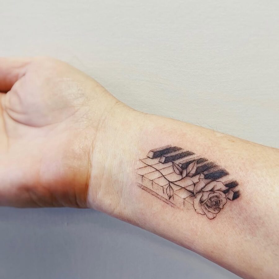 Intricate piano and rose tattoo blending art