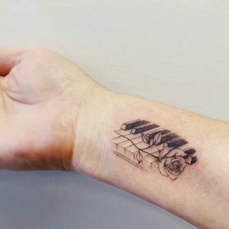 Intricate piano and rose tattoo blending art