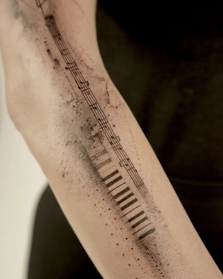 Minimalist piano tattoo with musical details