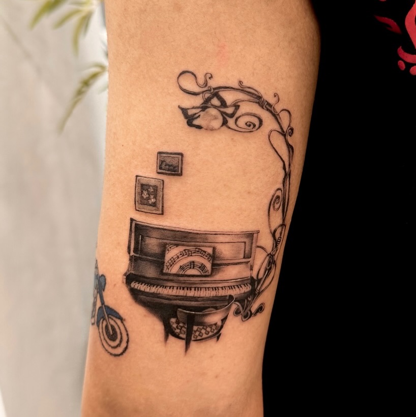 Elegant piano tattoo with artistic flourishes