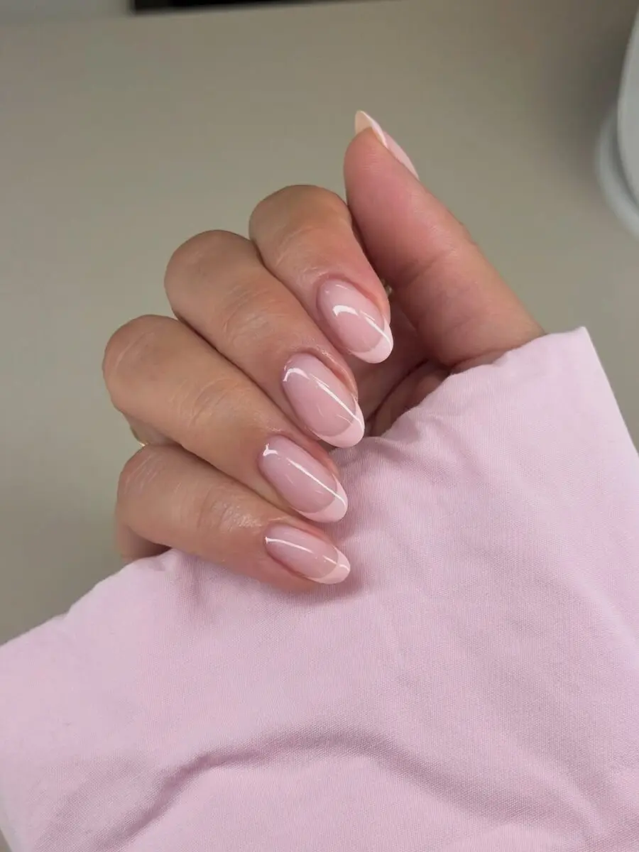 Stylish pink French tip nails with glossy finish