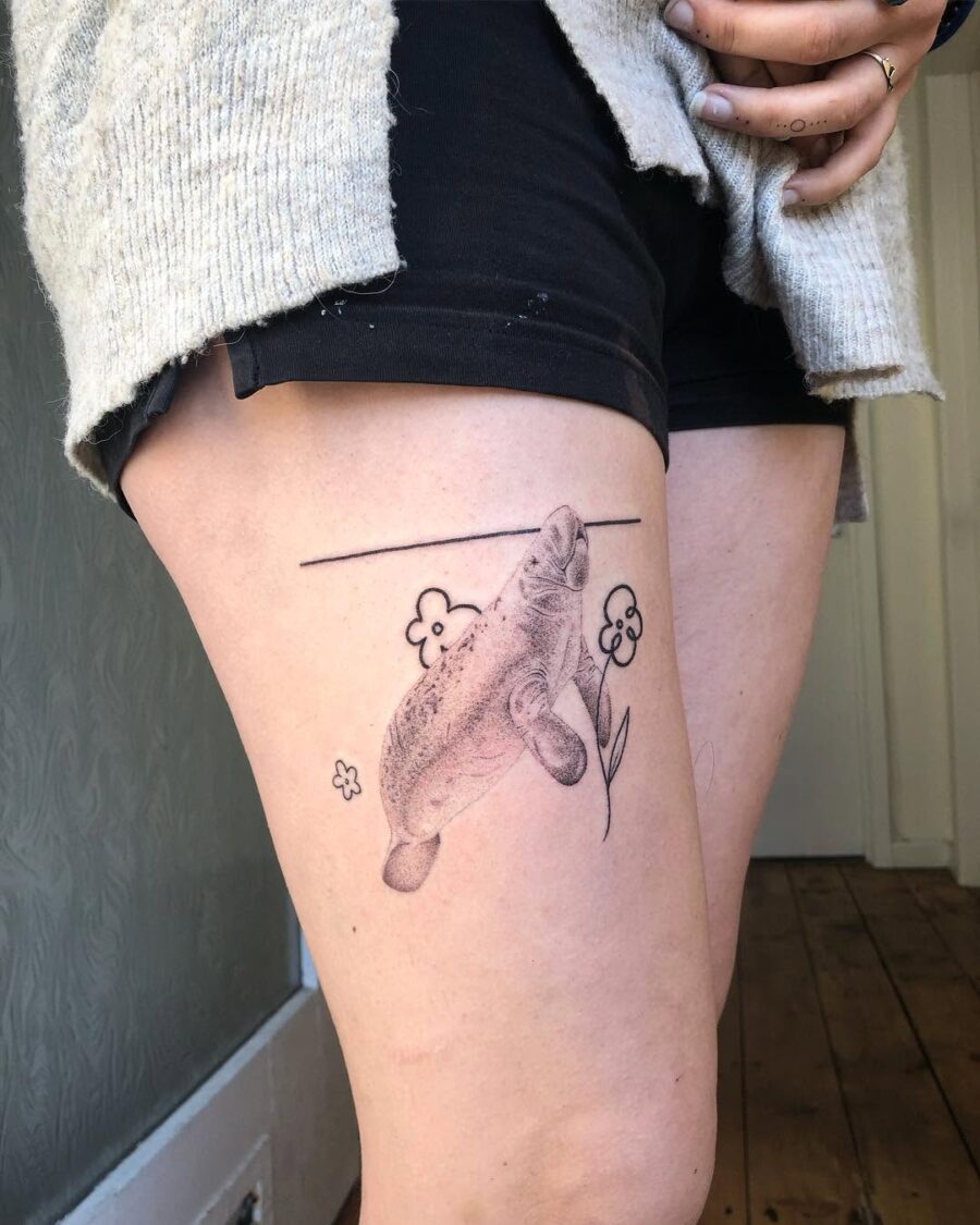Whimsical manatee tattoo on the thigh