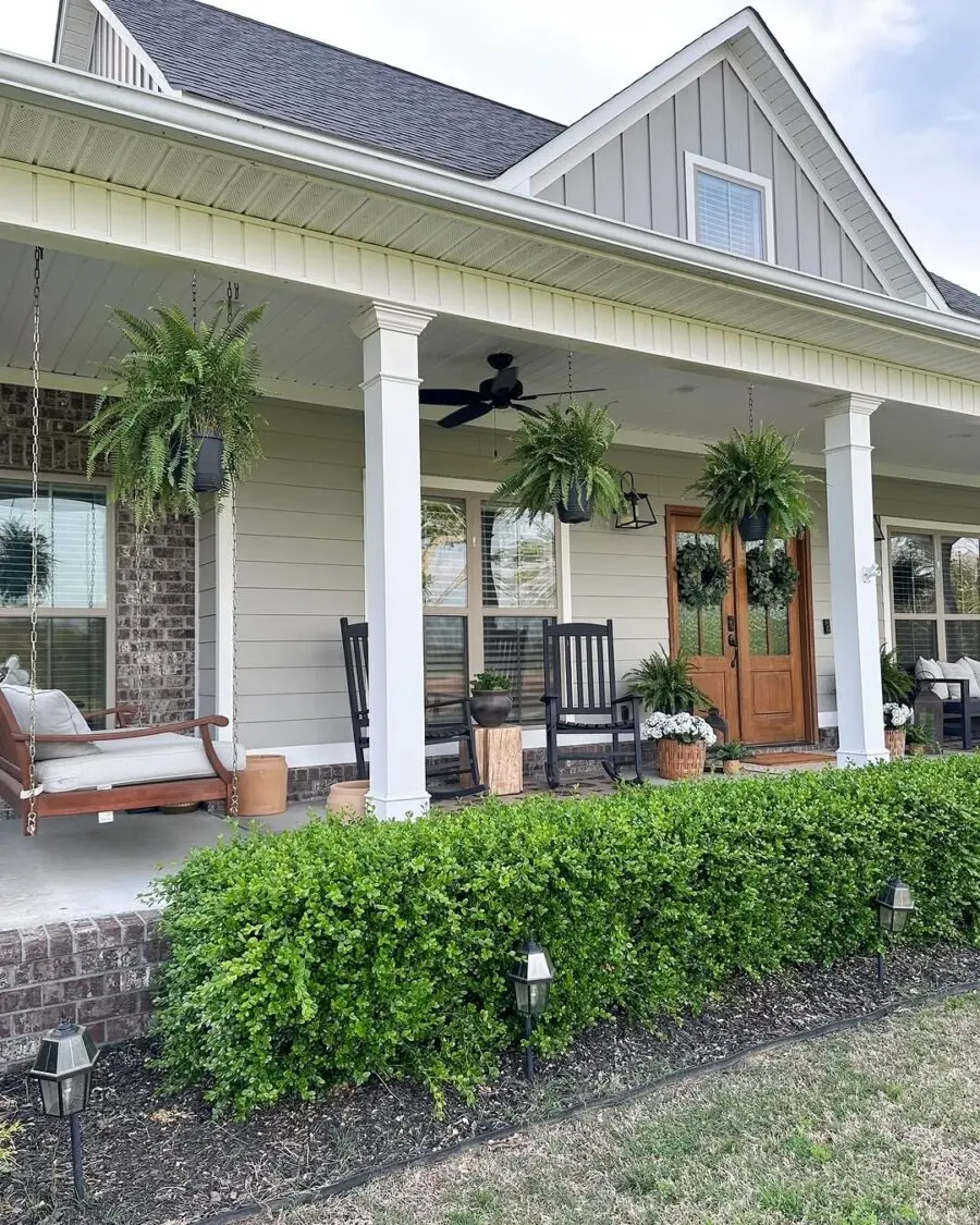 Charming porch with hanging ferns and cozy seating