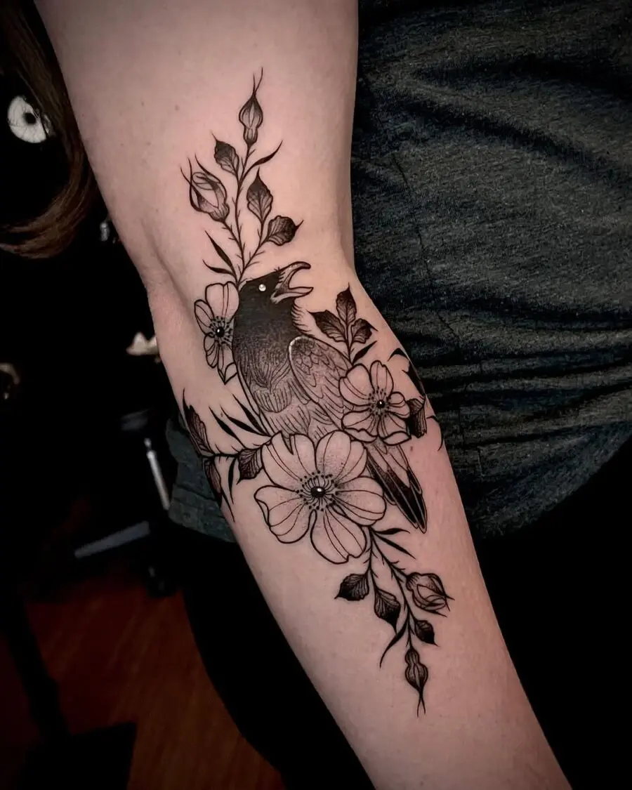 Elegant black ink raven tattoo with flowers