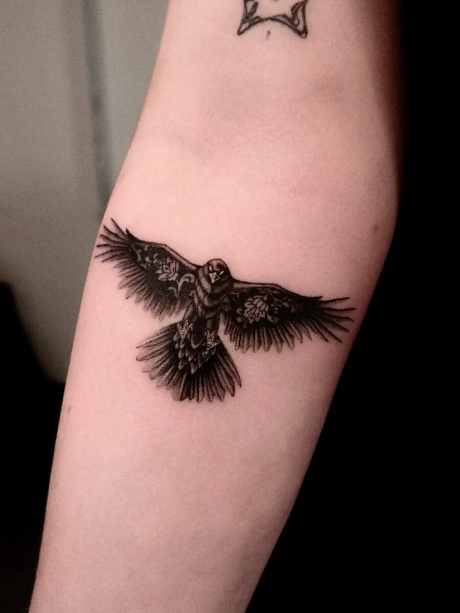Intricate raven tattoo with detailed feather design