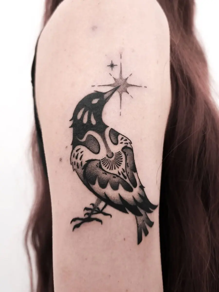 Elegant raven tattoo with striking starburst design