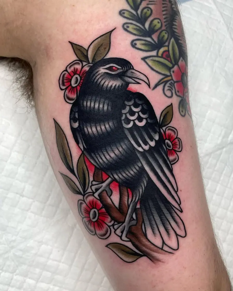 Striking raven tattoo with floral accents