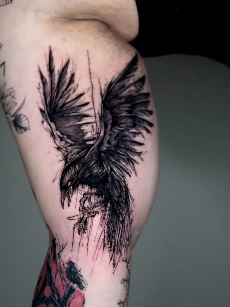 Striking black ink raven tattoo on thigh