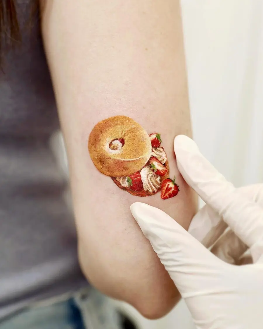 Delightful bagel tattoo with strawberry accents