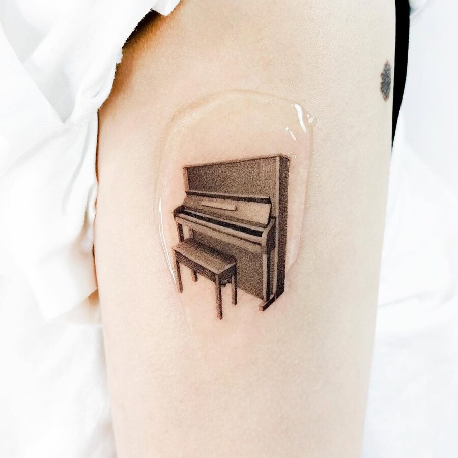 Elegant piano tattoo in realistic style