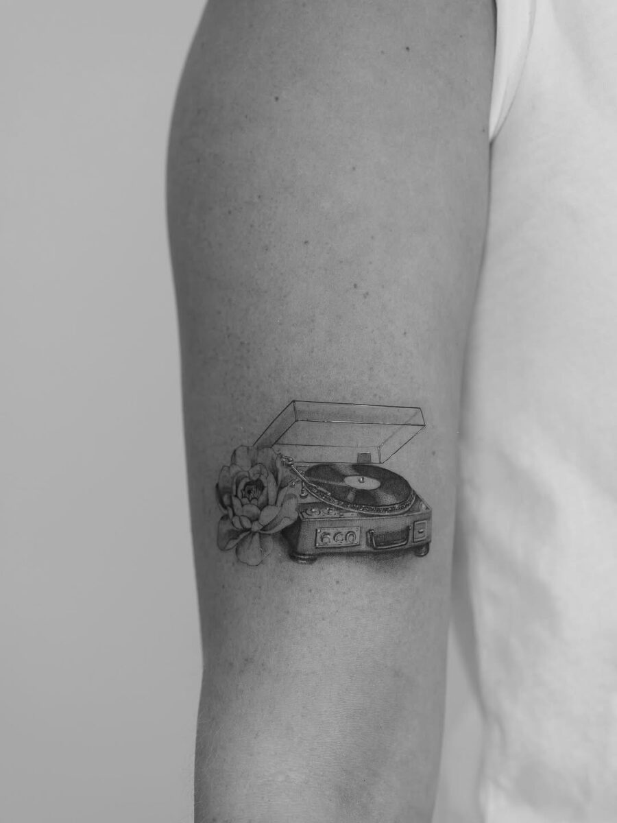 Elegant record player tattoo with floral elements