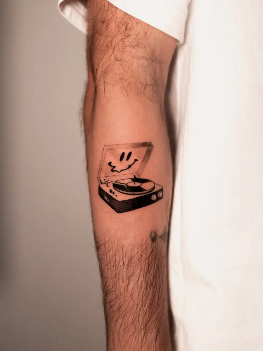 Playful record player tattoo with a smiley face