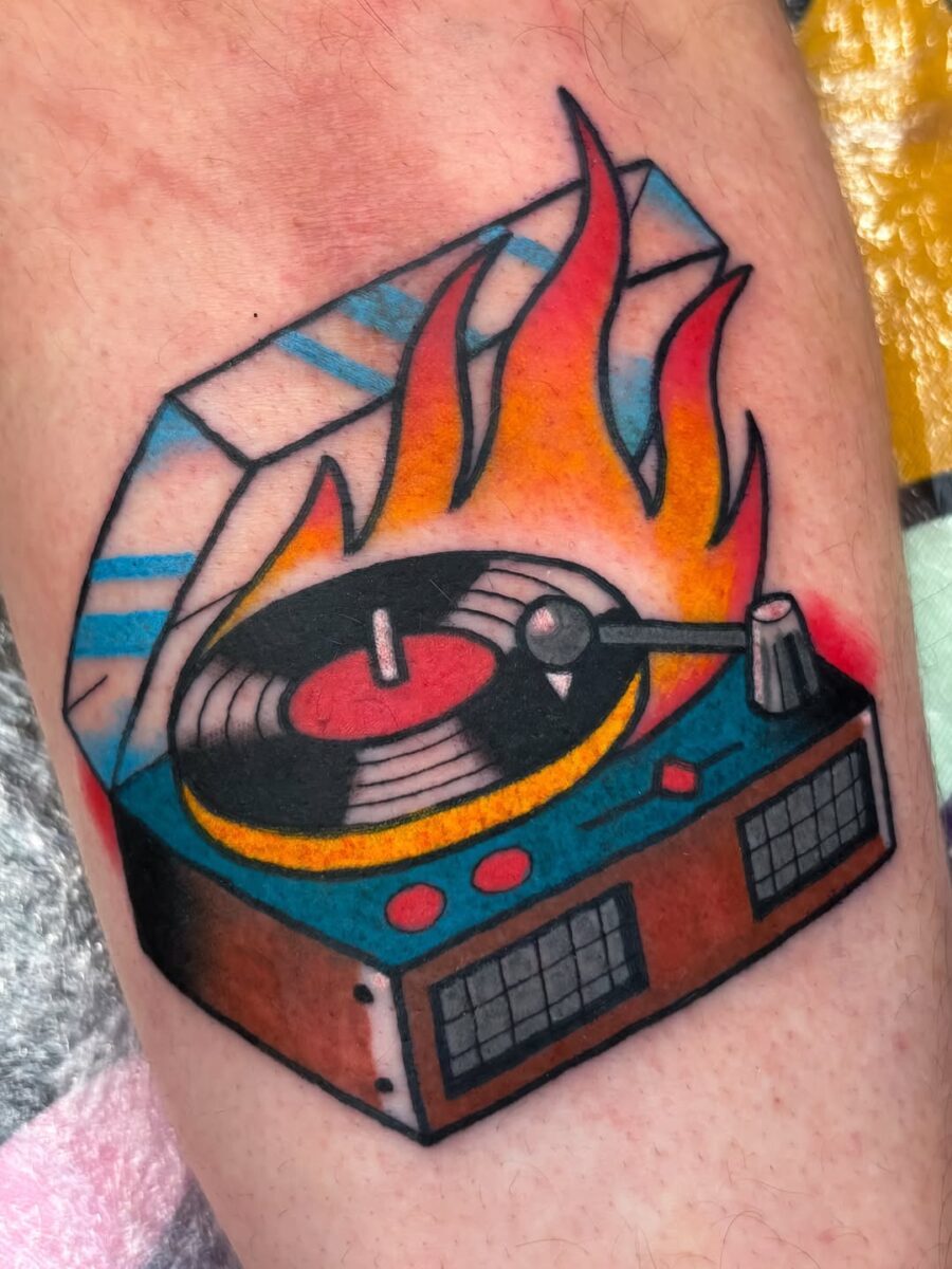 Vivid record player tattoo with fiery flair