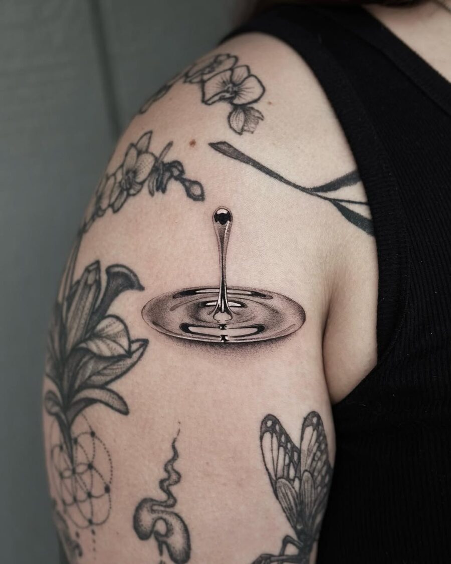 Striking silver droplet tattoo on the arm