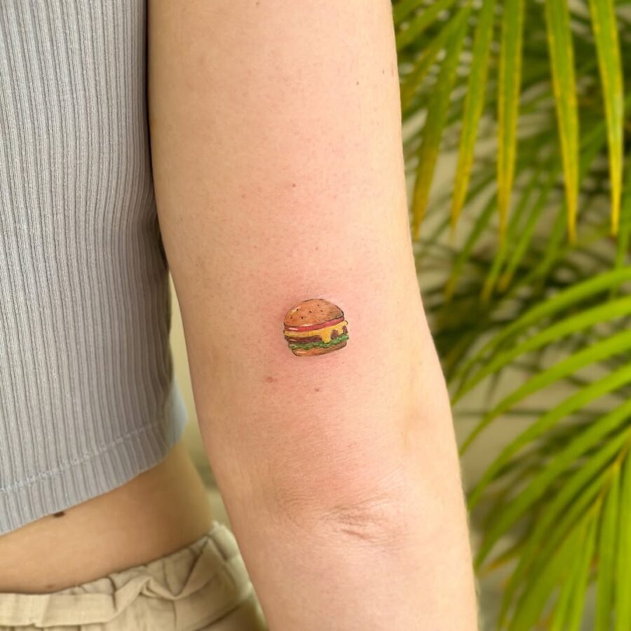 Charming small burger tattoo on the arm