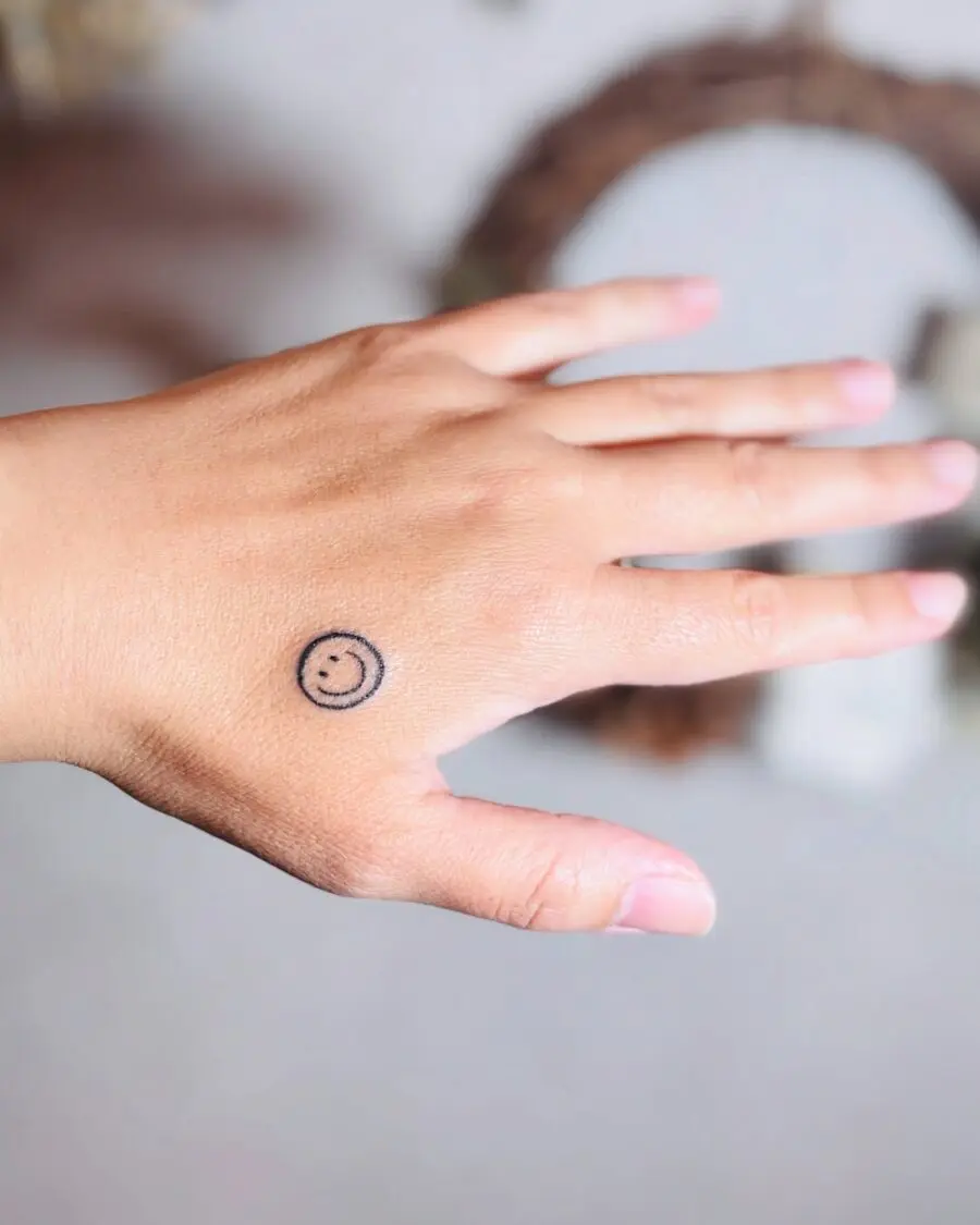 Charming smiley face tattoo on the hand